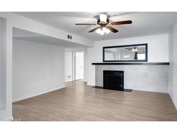 Bright living room featuring a fireplace, light wood floors, and neutral paint at 850 S River Dr # 1068, Tempe, AZ 85281