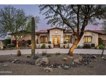 Inviting desert home featuring mature landscaping and a paver driveway at 8821 E Havasupai Dr, Scottsdale, AZ 85255