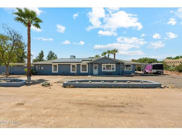 Charming single-story home with blue exterior and desert landscaping under a bright blue sky at 12501 E Cloud Rd, Chandler, AZ 85249