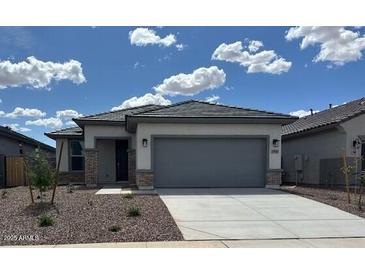 Charming single-story home featuring a gray roof, neutral stucco and a spacious two-car garage at 17043 W Fetlock Trl, Surprise, AZ 85387