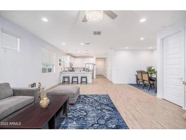 Open-concept living and dining areas with modern decor, seamlessly connected to a bright kitchen and comfortable seating at 17244 W West Wind Dr, Surprise, AZ 85387
