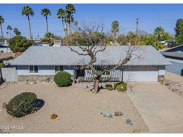 Charming single-story home featuring desert landscaping, gray tones and a spacious two-car garage at 3138 N 82Nd Pl, Scottsdale, AZ 85251