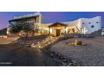 Stunning southwestern-style home with desert landscaping and illuminated walkway, offering inviting curb appeal at 3333 N 87Th St, Mesa, AZ 85207
