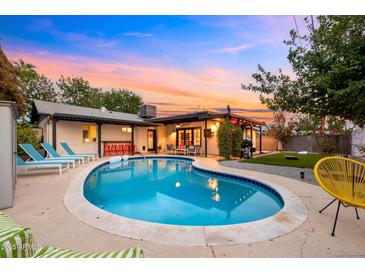 Beautiful backyard pool with lounge chairs, outdoor seating and colorful sky at dusk at 4020 N 34Th St, Phoenix, AZ 85018
