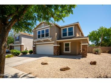 Tan two story home with a two car garage and a gravel yard at 4349 E Windsor Ct, Gilbert, AZ 85296