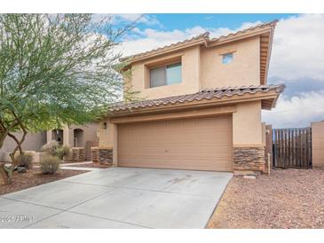 Inviting two-story home featuring desert landscaping and a two-car garage at 6528 S 258Th Dr, Buckeye, AZ 85326