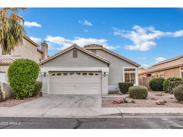 Charming single-story home featuring a two-car garage, desert landscaping, and a neutral color palette at 668 S Catalina St, Gilbert, AZ 85233