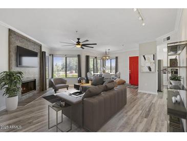 Inviting living room with fireplace, TV, and dining area with great lighting at 7575 E Indian Bend Rd # 2002, Scottsdale, AZ 85250