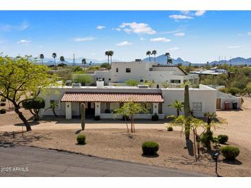 Stunning aerial view of a luxurious estate with tile roof surrounded by desert landscape and palm trees at 9224 N 126Th St, Scottsdale, AZ 85259