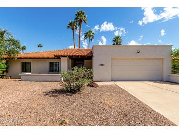 Charming single-story home featuring a desert landscape, an attached garage, and palm trees at 9629 N 83Rd Way, Scottsdale, AZ 85258