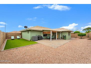 Backyard featuring patio with seating, desert landscaping, and turf at 11010 E Keats Ave, Mesa, AZ 85209