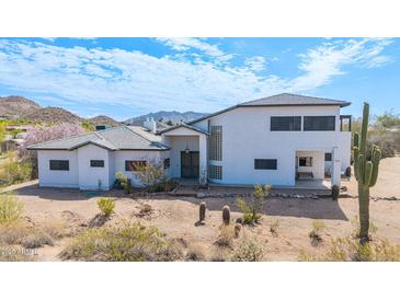 Desert home featuring white stucco, a tile roof, and arid landscaping with mature cactus at 3215 N 83Rd St, Mesa, AZ 85207