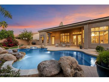 Beautiful outdoor living space with pool, rock features, and covered patio, perfect for relaxing evenings and entertaining guests at 1082 W Thompson Way, Chandler, AZ 85286