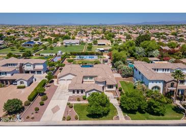 Expansive estate featuring a private pool, lush landscaping, a circular driveway, and a three-car garage at 3356 E Vallejo Ct, Gilbert, AZ 85298
