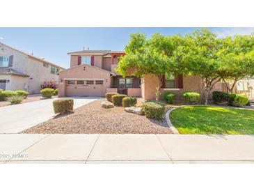Beautiful two-story home featuring a well-maintained lawn, mature landscaping, and a two-car garage at 747 E Charlevoix Ave, Gilbert, AZ 85297
