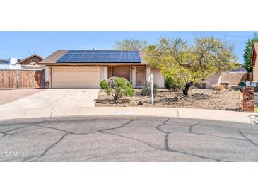 Charming single-story home featuring a two-car garage and solar panels on the roof at 10438 W Butler Dr, Peoria, AZ 85345