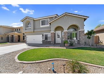 Charming two-story home featuring a well-manicured lawn, stone accents and neutral-colored stucco at 11225 E Sylvan Ave, Mesa, AZ 85212