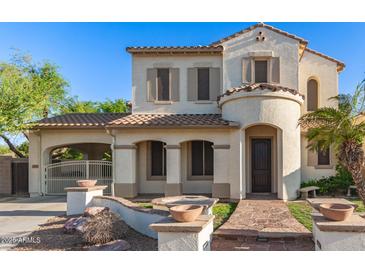Charming two-story home featuring a stucco exterior, tile roof, and gated driveway entrance at 12911 W Campbell Ave, Litchfield Park, AZ 85340