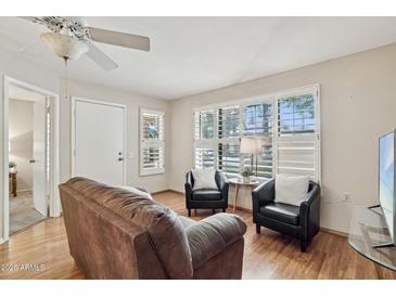 Bright living room featuring plantation shutters and comfortable seating at 14300 W Bell Rd # 145, Surprise, AZ 85374