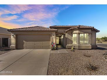 Charming home exterior with a two-car garage, low maintenance desert landscaping, and a welcoming front entrance at 17152 W Watkins St, Goodyear, AZ 85338