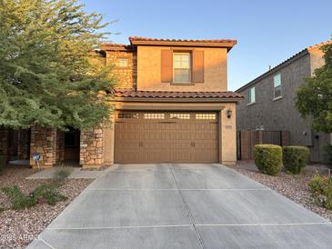 Two-story home featuring a stone column and a brown two-car garage against a blue sky at 2665 E Gillcrest Rd, Gilbert, AZ 85298