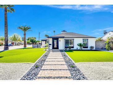 Charming single-story home with manicured lawn, stone pathway, and inviting entrance on a sunny day at 2926 N 16Th Ave, Phoenix, AZ 85015