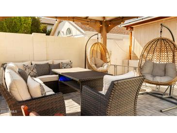 Cozy covered patio area with comfortable seating and stylish hanging chairs at 3017 E Bluefield Ave, Phoenix, AZ 85032