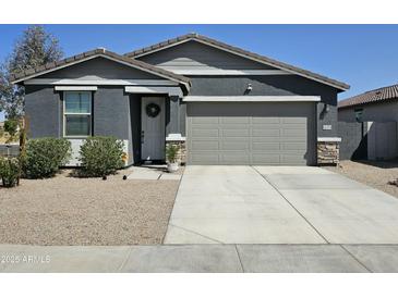 Charming single-story home features a two-car garage, a gray color scheme, and manicured landscaping at 36354 W San Clemente Ave, Maricopa, AZ 85138