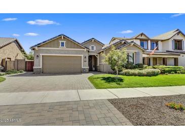 Charming single-story home features manicured lawn, brick driveway, and a two-car garage at 7407 E Portobello Ave, Mesa, AZ 85212