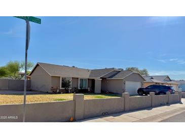 Charming single-story home featuring a low-walled front yard and a two-car garage at 7901 W Tuckey Ln, Glendale, AZ 85303