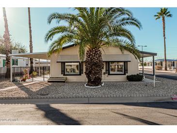 Charming home exterior featuring desert landscaping, a covered carport, and a mature palm tree at 16246 N 32Nd Way, Phoenix, AZ 85032
