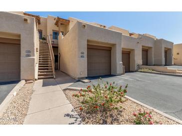 Exterior view of a well maintained multi-unit building with individual garages and private entrances at 16307 E Arrow Dr # 104, Fountain Hills, AZ 85268