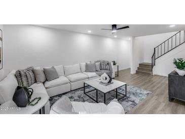 Bright living room features a modern sofa, stylish coffee table, and a staircase on the right side at 3416 N 44Th St # 51, Phoenix, AZ 85018
