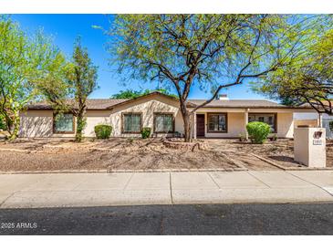 Charming single-story home featuring desert landscaping, mature trees, and a welcoming front porch at 14815 N 21St St, Phoenix, AZ 85022
