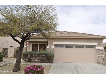 Charming single-story home featuring stone accents, a two-car garage, and manicured landscaping at 17810 W Marshall Ln, Surprise, AZ 85388