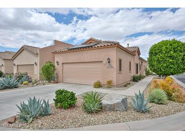 Southwest home showcasing desert landscaping, a two-car garage and a tile roof under partly cloudy skies at 18650 N 91St Ave # 3701, Peoria, AZ 85382
