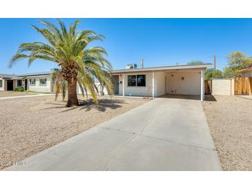 Charming home featuring desert landscaping, covered parking, and a mature palm tree for added curb appeal at 3306 W Lupine Ave, Phoenix, AZ 85029