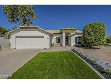 Charming single-story home with a well-manicured lawn, desert landscaping, and a two-car garage at 3802 W Sheffield Ave, Chandler, AZ 85226