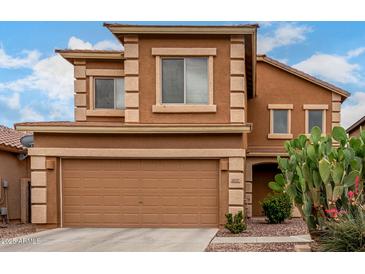 Inviting two-story home featuring a two-car garage and desert landscaping at 41227 W Granada Dr, Maricopa, AZ 85138