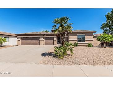 Charming single-story home featuring a well-manicured front yard with desert landscaping and a three-car garage at 4718 E Decatur St, Mesa, AZ 85205