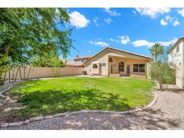 Large backyard featuring lush green grass, mature trees, and a privacy fence at 4811 W Oakland St, Chandler, AZ 85226