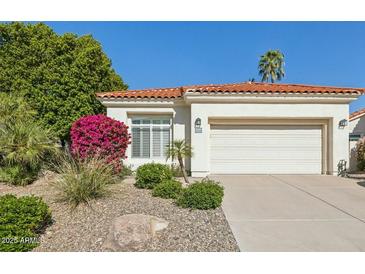 Charming home featuring a vibrant bougainvillea bush, desert landscaping, and a classic terracotta tile roof at 9540 N 114Th Way, Scottsdale, AZ 85259