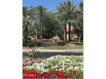 The Racquet Club community entrance features lush landscaping, mature palm trees and stone signage at 9708 E Via Linda -- # 1338, Scottsdale, AZ 85258