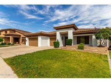 Inviting single-story home boasts a lush lawn, desert landscaping, and a three-car garage at 702 E Capricorn Way, Chandler, AZ 85249