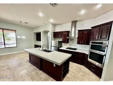 A spacious kitchen with a large island and updated, stainless steel appliances and plenty of storage space at 702 E Capricorn Way, Chandler, AZ 85249