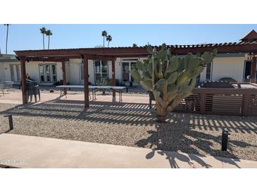 Exterior view of the home with a pergola and desert landscaping at 10039 W Lancaster Dr, Sun City, AZ 85351