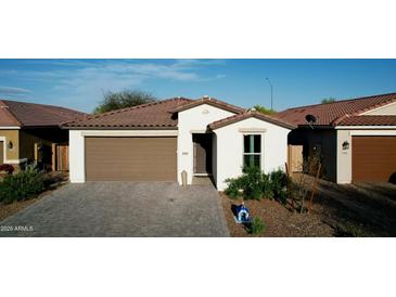 Charming single-story home with a well-manicured front yard and a brick paved driveway at 1972 N Loretta Pl, Casa Grande, AZ 85122