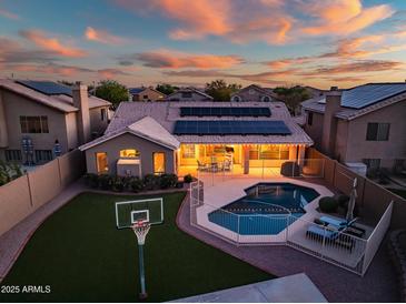 Sunset aerial view of the house highlighting a private pool and lush backyard with a basketball court at 29227 N 44Th St, Cave Creek, AZ 85331
