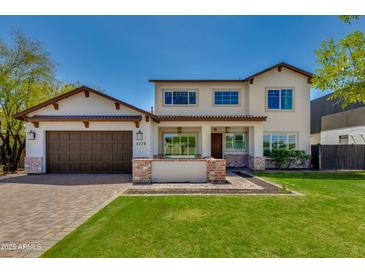Inviting two-story home with a manicured lawn, brick accents, and a charming front porch at 3229 E Campbell Ave, Phoenix, AZ 85018