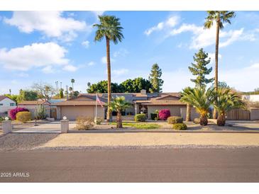 Charming ranch-style home with desert landscaping, mature palm trees, and an inviting front yard at 7240 W Grovers Ave, Glendale, AZ 85308